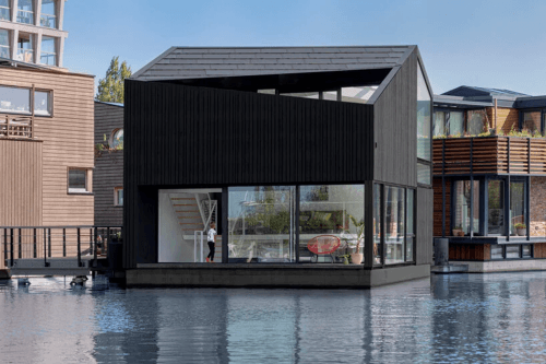 Этот угловой деревянный дом в устойчивой плавучей деревне Амстердама использует электрическую сеть причала для получения экологически чистой энергии!